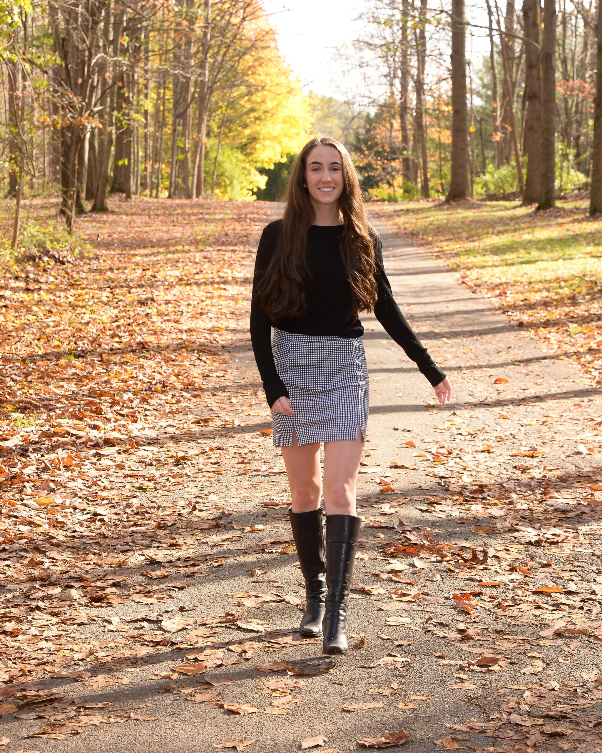A young woman walking down a road in the fall